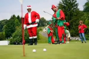 Mark Creamer, right, and Kyle Kappmeier, left, dressed as a Christmas elf and Santa, putt on the green at the Great Gorge Golf Club to kick off their 12 Days of Christmas in July event.