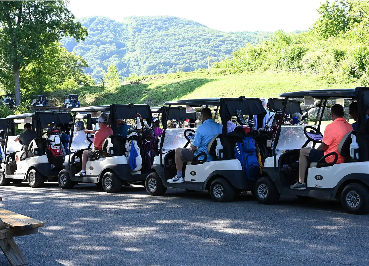 Group of golfers in their golf carts at The Great Gorge in Vernon, NJ, enjoying a lively outing, with scenic fairways and the beautiful landscape of the course in the background.