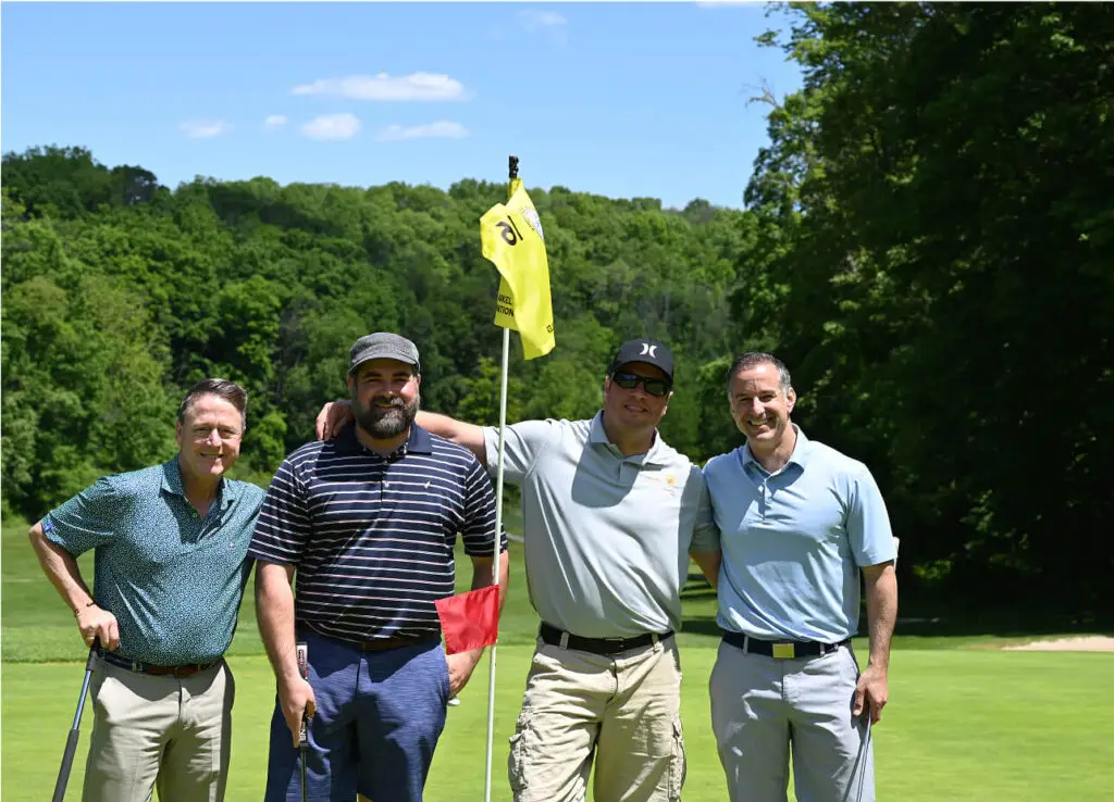 Three men posing together during a golf outing at The Great Gorge in Vernon, NJ, smiling and enjoying the event, with the course and scenic landscape in the background.