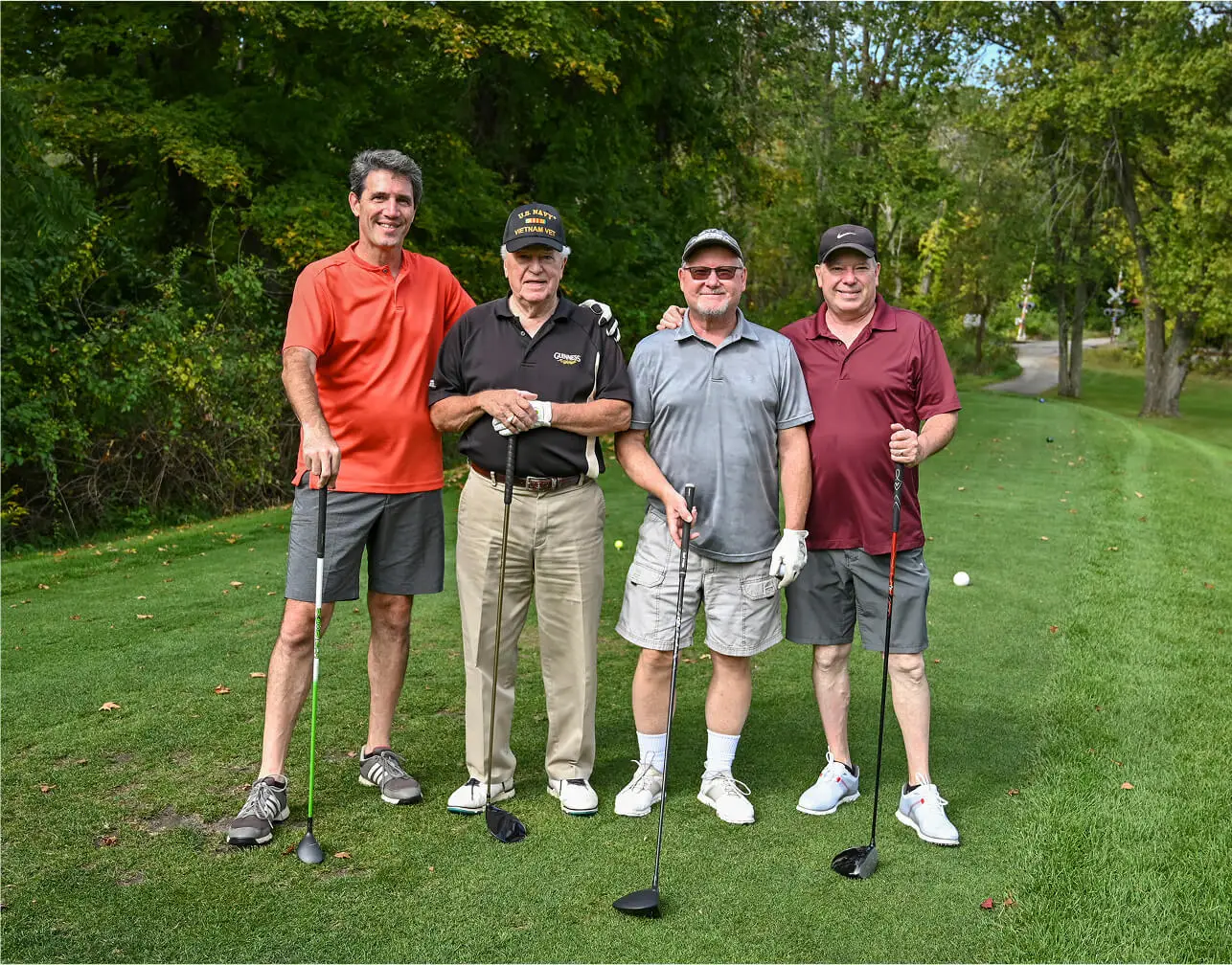 Group of men posing at The Great Gorge in Vernon, NJ, representing the civil service discount, smiling proudly with the golf course and natural landscape in the background.
