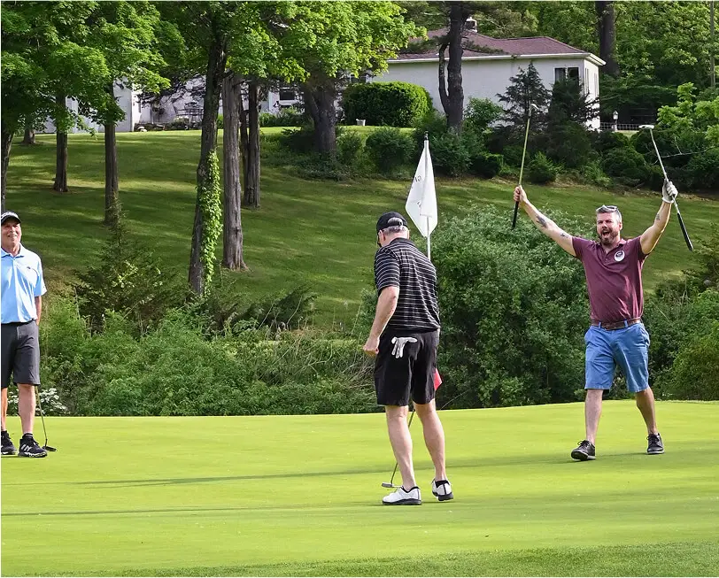 Group of men playing golf at The Great Gorge in Vernon, NJ, focused on their shots with scenic fairways and natural landscapes in the background.